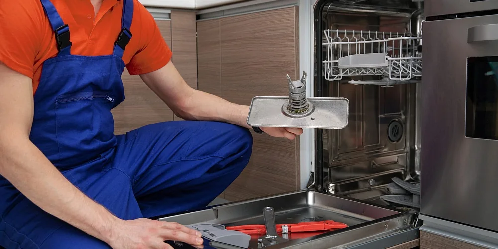 Technician servicing a dishwasher filter and interior components