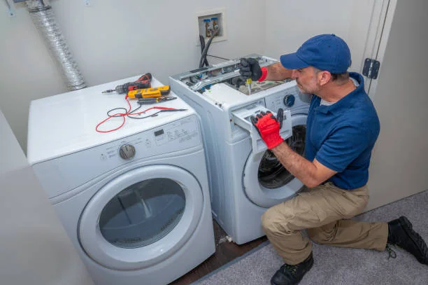 Technician checking washer and dryer components in a laundry room
